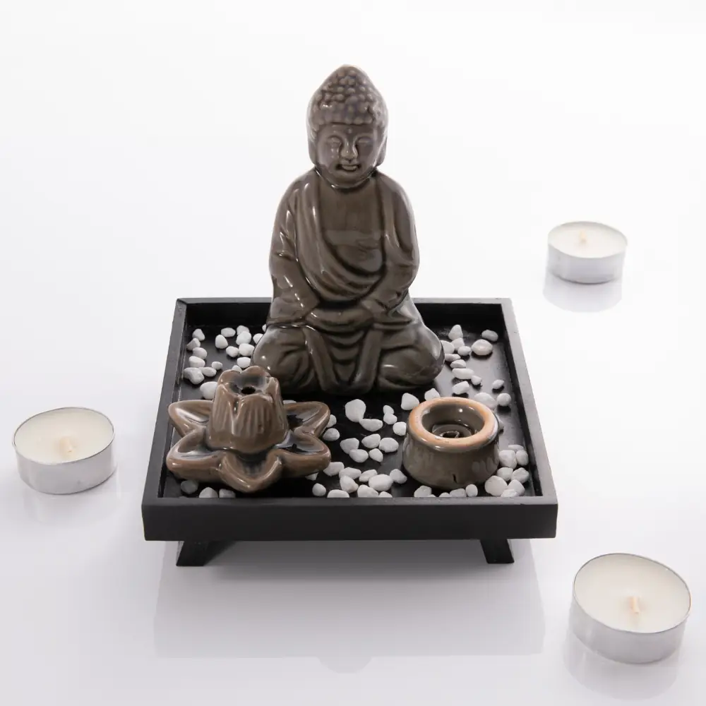 Statuette de Bouddha Myga sur un plateau noir avec pierres décoratives et supports pour encens.