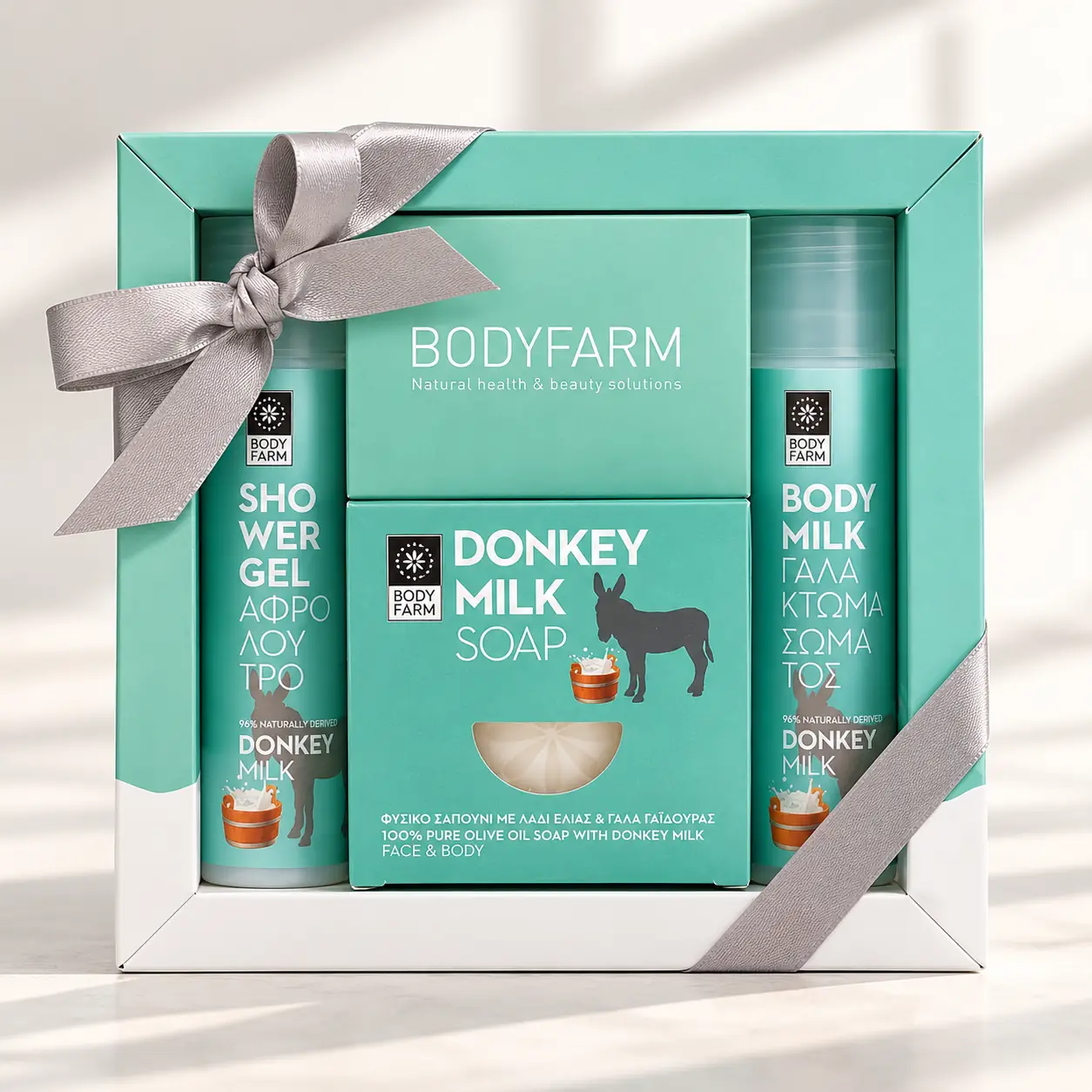 Coffret cadeau bien-être Bodyfarm au lait d’ânesse avec gel douche, lotion pour le corps et savon, dans une boîte avec ruban.