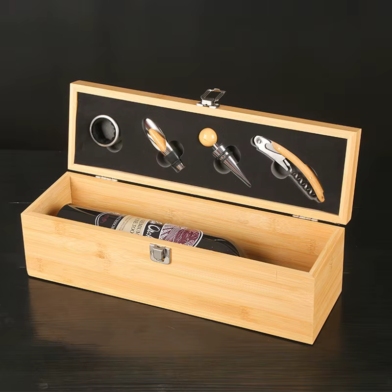 Coffret à vin en bois naturel ouvert avec bouteille de Merlot et accessoires de service